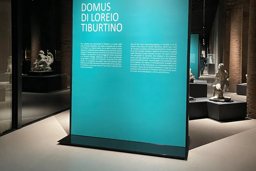 Pannello retroilluminato del percorso espositivo agli Scavi di Pompei, fra statue e colonne in laterizio